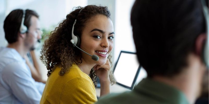 Female underwriter speaking to small business owner on the phone about funding.